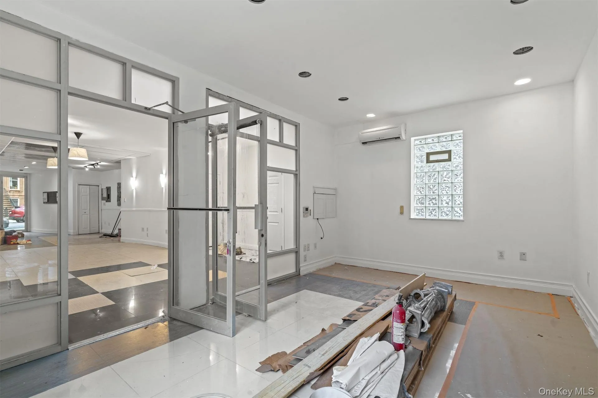 Empty room featuring tile patterned flooring, a wall mounted air conditioner, and recessed lighting Empty room featuring tile patterned flooring, a wall mounted air conditioner, and recessed lighting