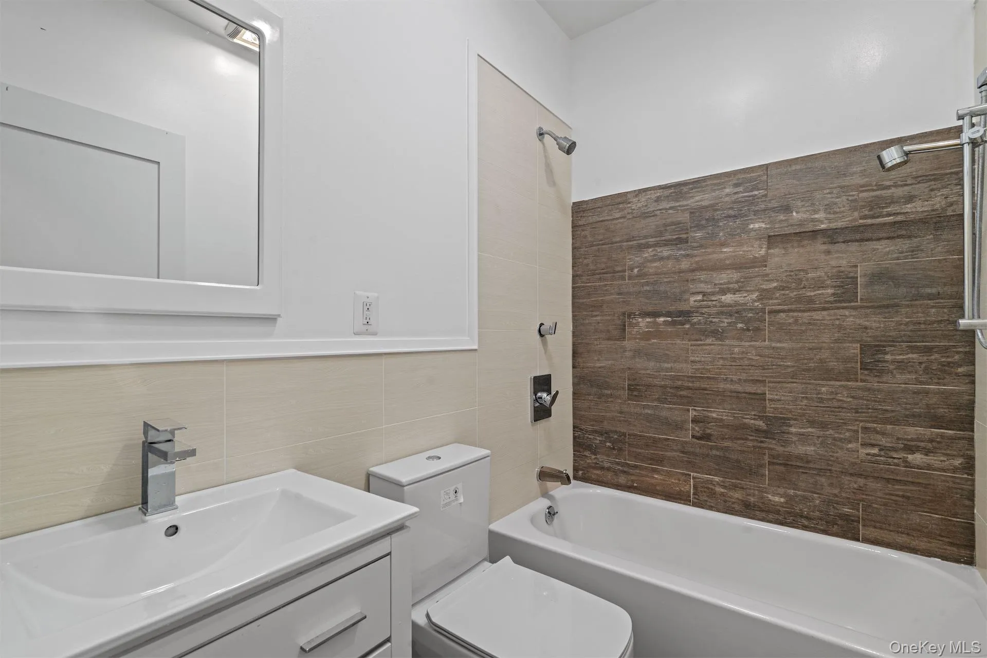 Full bath featuring shower / washtub combination, vanity, and tile walls Full bath featuring shower / washtub combination, vanity, and tile walls