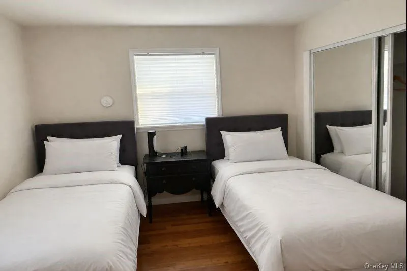 Bedroom featuring dark wood-style floors and a closet Bedroom featuring dark wood-style floors and a closet