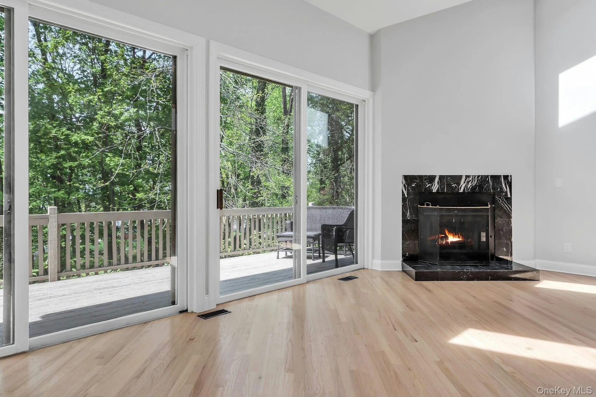Grand living room with fireplace and sliding doors out to the deck for alfresco dining and winter water views Grand living room with fireplace and sliding doors out to the deck for alfresco dining and winter water views
