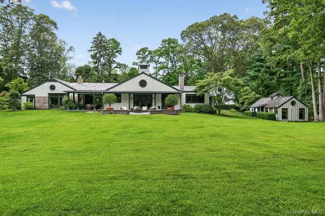 Back of the home on a glorious 5.5 arboretum like acres. Back of the home on a glorious 5.5 arboretum like acres.