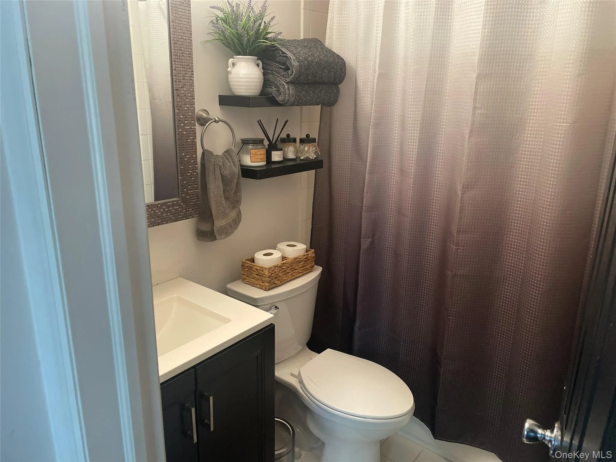 Bathroom with toilet, vanity, and a shower with shower curtain Bathroom with toilet, vanity, and a shower with shower curtain
