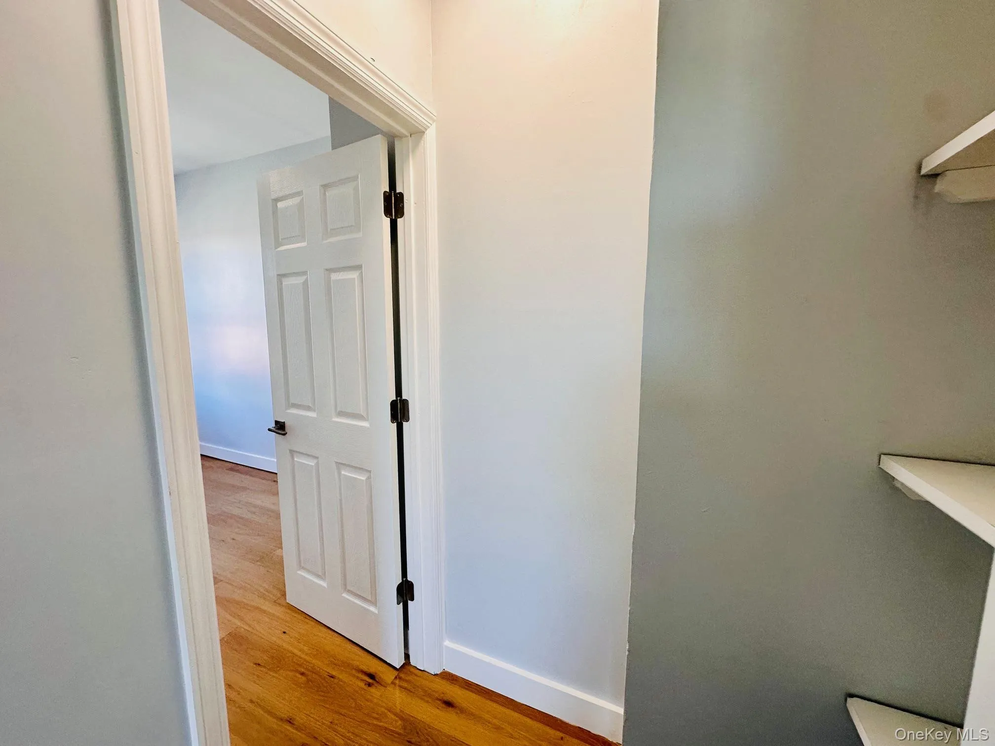 Hall featuring baseboards and light wood-style floors Hall featuring baseboards and light wood-style floors