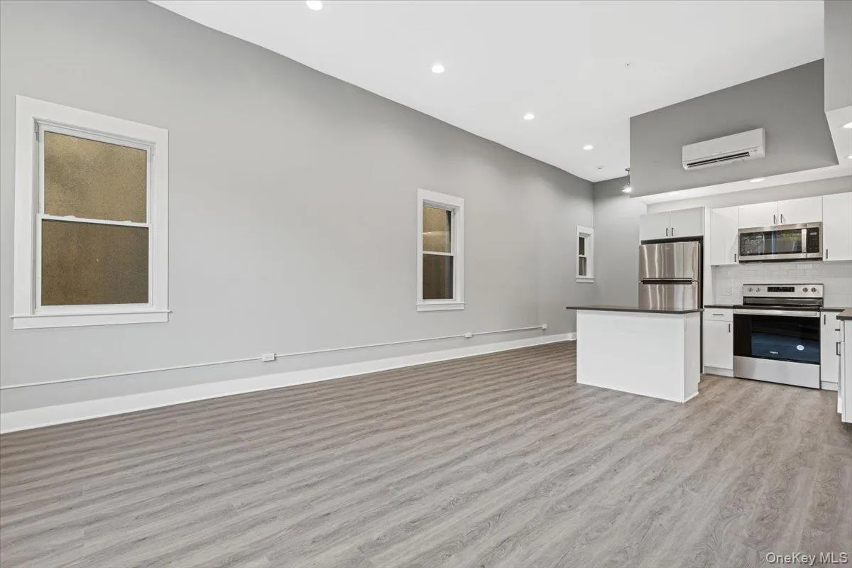 Kitchen with stainless steel appliances, open floor plan, white cabinets, recessed lighting, and light wood-type flooring Kitchen with stainless steel appliances, open floor plan, white cabinets, recessed lighting, and light wood-type flooring