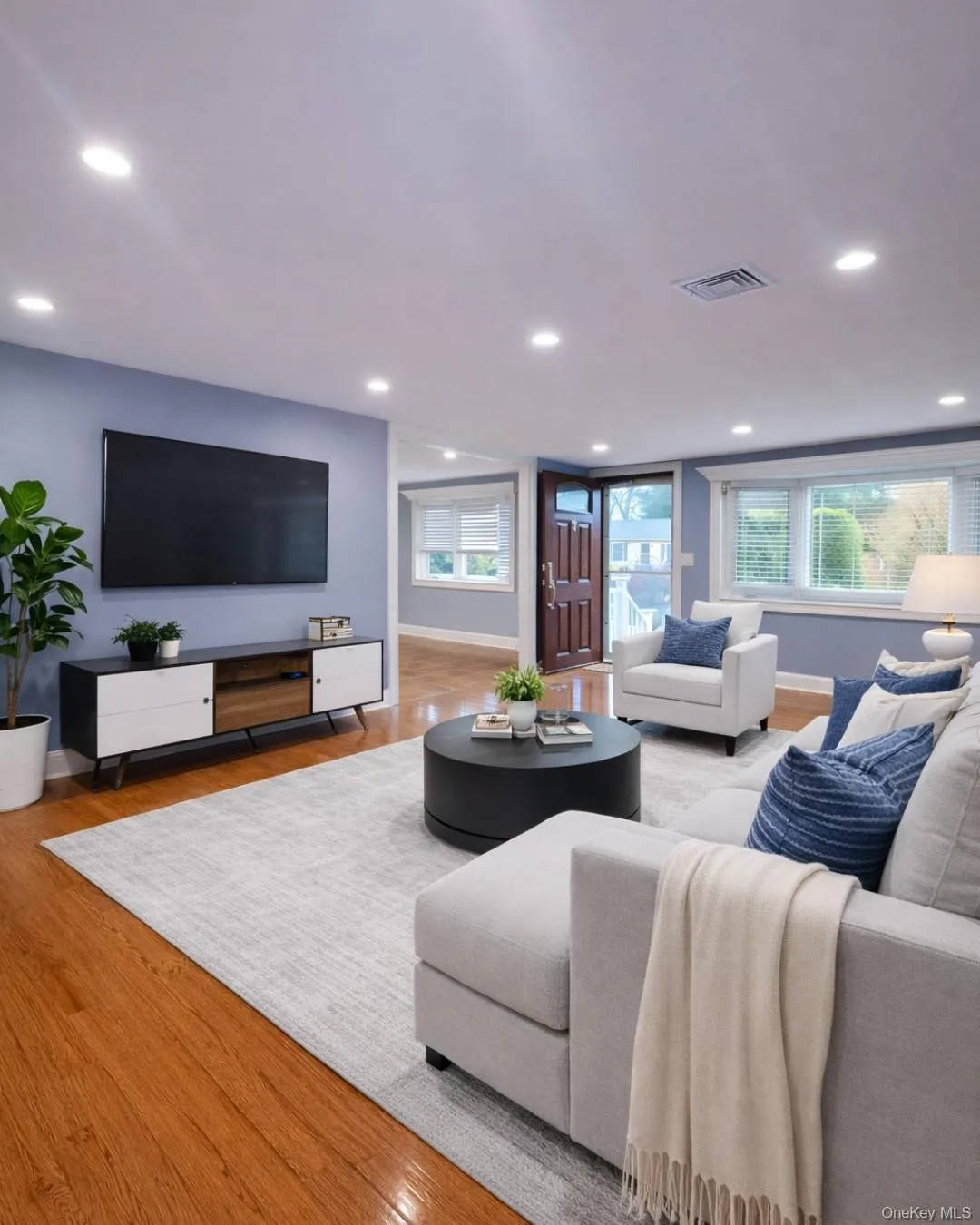 Living room featuring light wood-type flooring, healthy amount of natural light, and recessed lighting Living room featuring light wood-type flooring, healthy amount of natural light, and recessed lighting