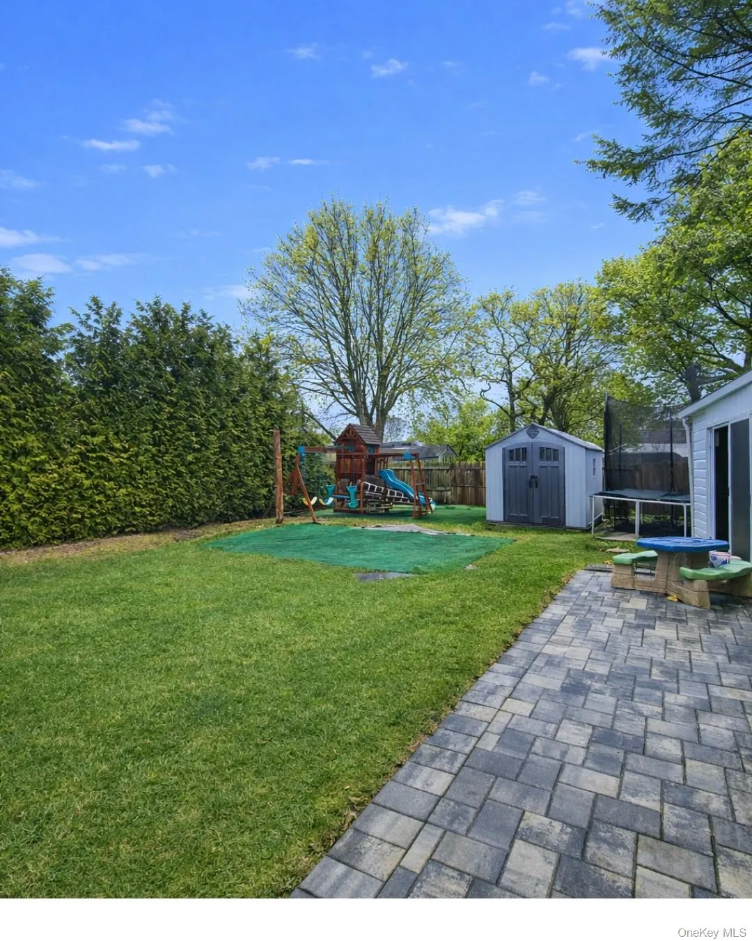 Fenced backyard featuring a trampoline, a playground, a shed, and a patio area Fenced backyard featuring a trampoline, a playground, a shed, and a patio area