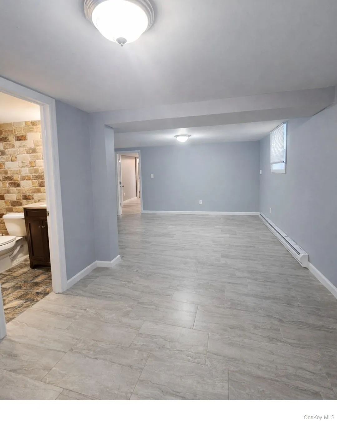Finished basement featuring a baseboard radiator and baseboards Finished basement featuring a baseboard radiator and baseboards