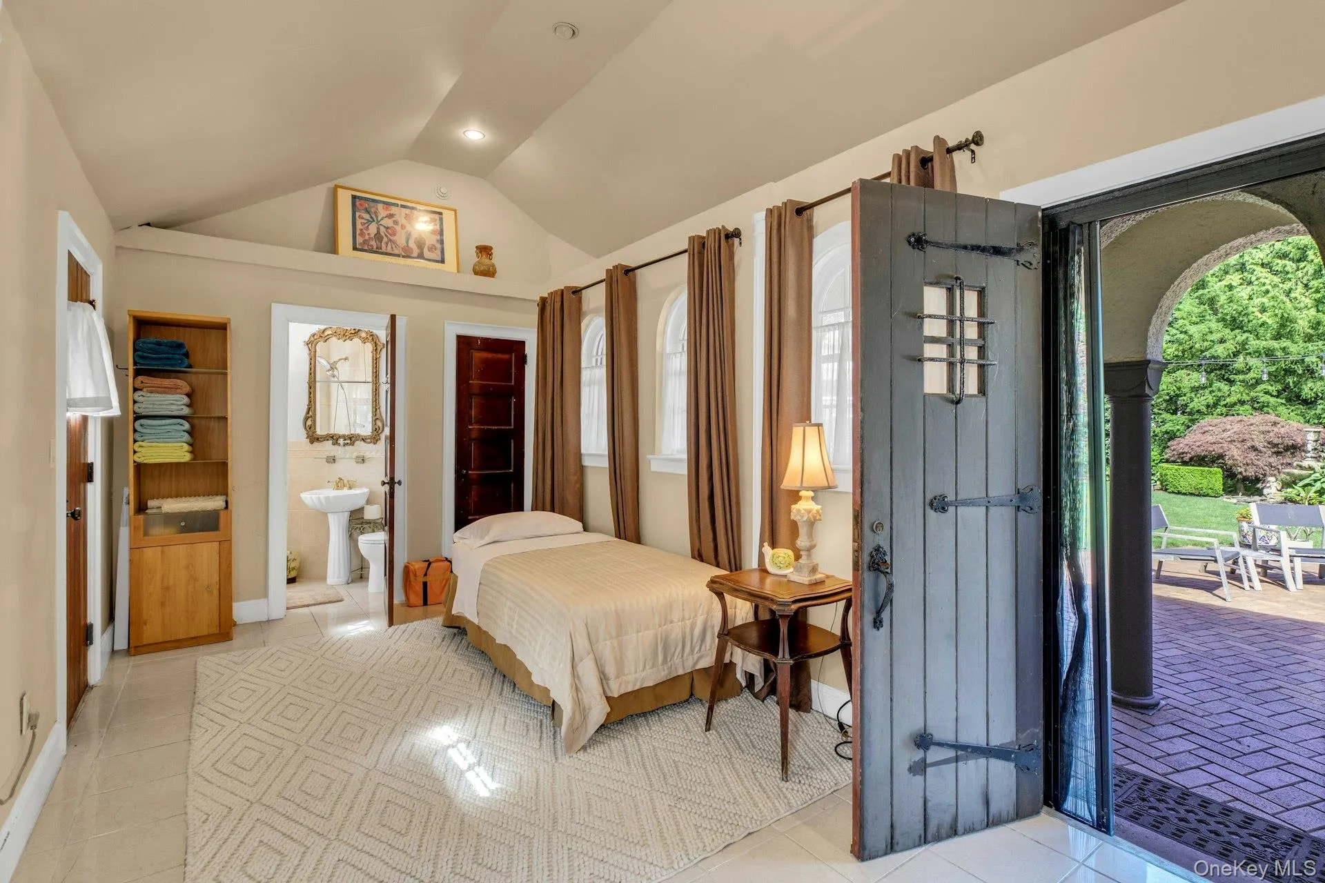 Guest cottage with lofted ceiling, access to exterior, light tile patterned floors, and ensuite full bathroom Guest cottage with lofted ceiling, access to exterior, light tile patterned floors, and ensuite full bathroom