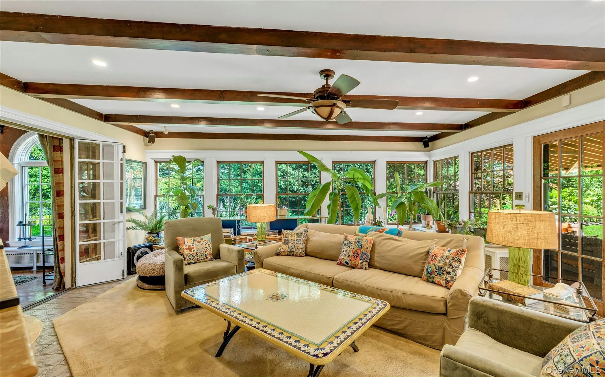 Southwest facing great room oozing with natural light, featuring beam ceiling, recessed lighting, french doors to den and back door leading to brick patio Southwest facing great room oozing with natural light, featuring beam ceiling, recessed lighting, french doors to den and back door leading to brick patio