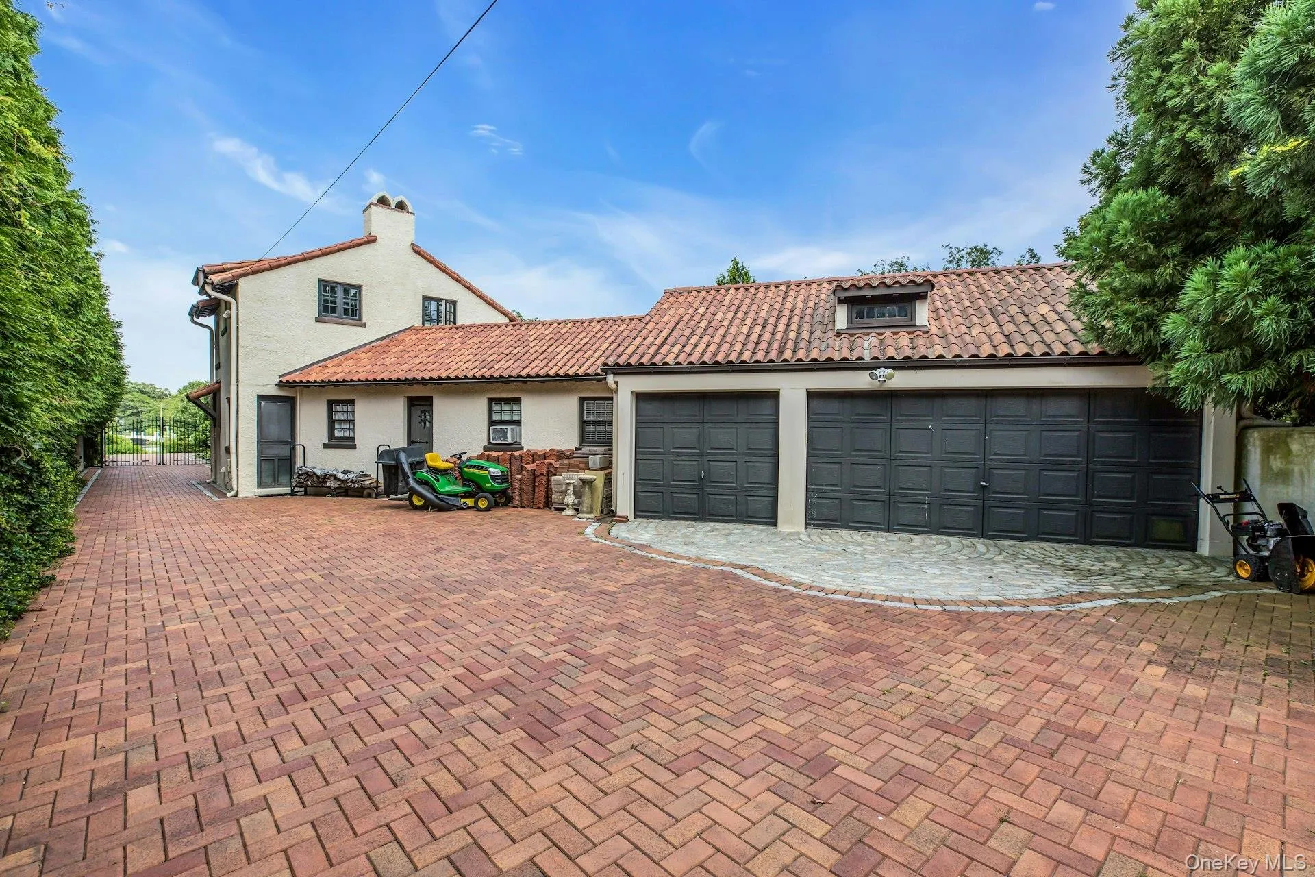 Mediterranean / spanish-style house with stucco siding, a 3 car attached garage, a tiled roof, and pavered driveway Mediterranean / spanish-style house with stucco siding, a 3 car attached garage, a tiled roof, and pavered driveway
