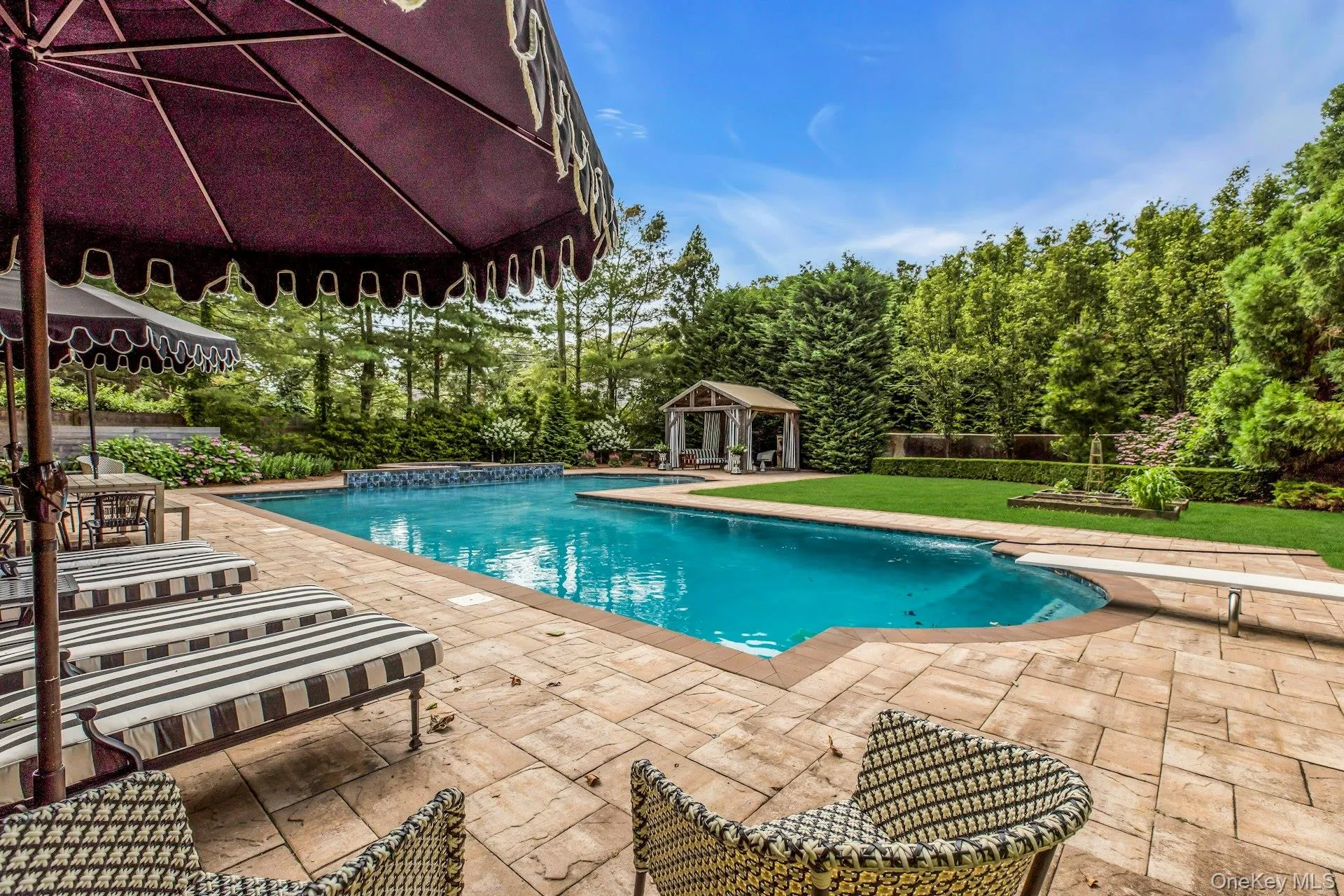 L-Shaped tiled gunite saltwater gas heated pool, with attached circular in-ground spa L-Shaped tiled gunite saltwater gas heated pool, with attached circular in-ground spa