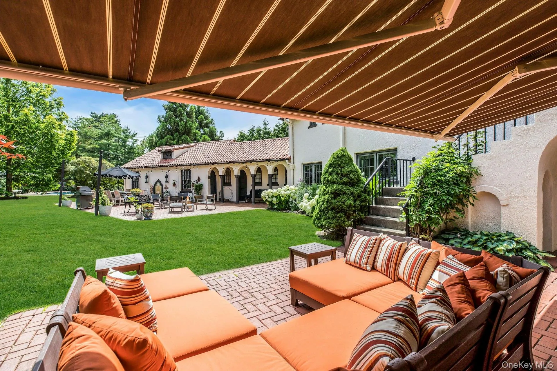 Ground floor brick patio off great room, featuring outdoor lounge area with awning Ground floor brick patio off great room, featuring outdoor lounge area with awning