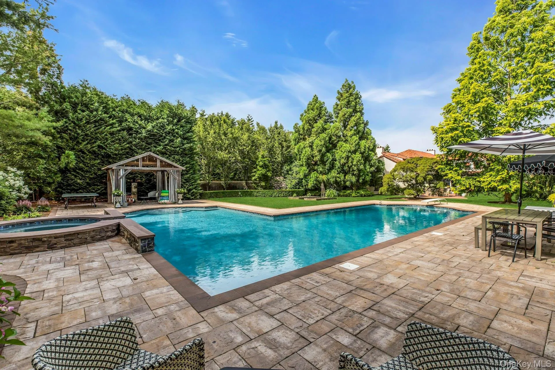 L-Shaped tiled gunite saltwater gas heated pool, with attached circular in-ground spa L-Shaped tiled gunite saltwater gas heated pool, with attached circular in-ground spa