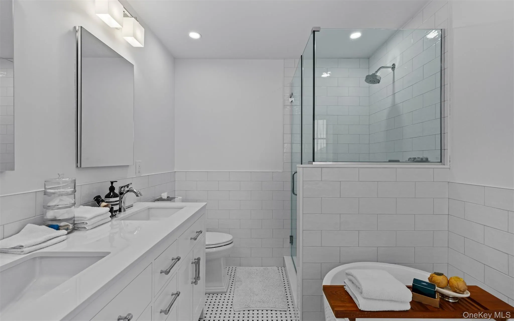 Brand new primary full bath w/dual vanity, frameless glass shower enclosure, freestanding soaking tub, white subway tile accents, and recessed lighting Brand new primary full bath w/dual vanity, frameless glass shower enclosure, freestanding soaking tub, white subway tile accents, and recessed lighting