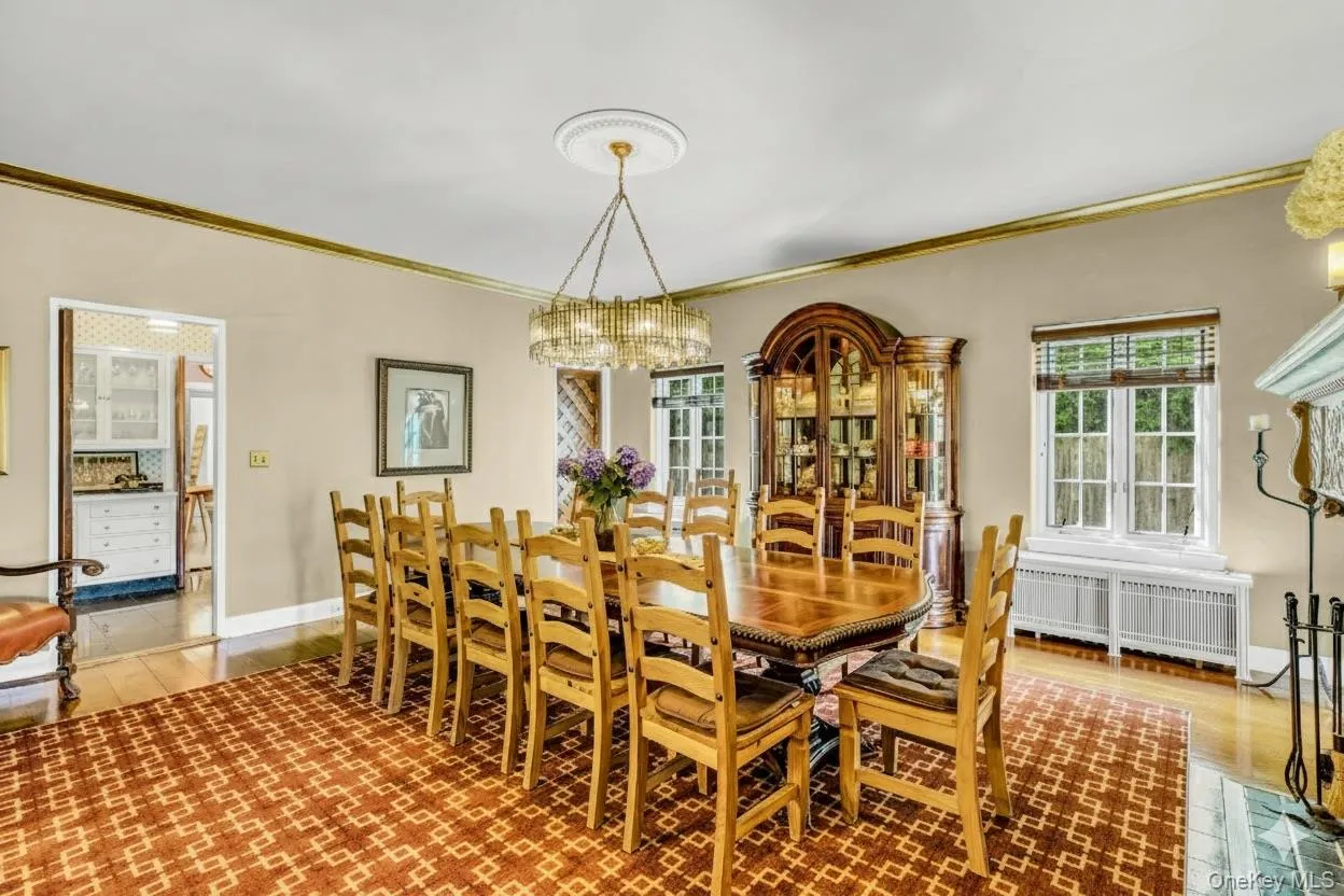 Dining area featuring ornamental molding, radiator, a chandelier, and wood finished floors Dining area featuring ornamental molding, radiator, a chandelier, and wood finished floors
