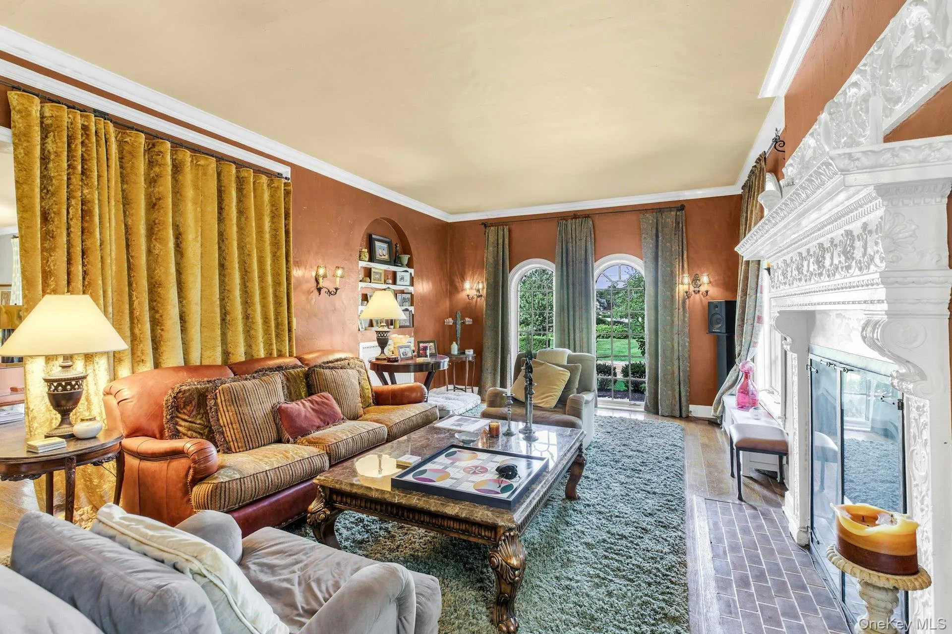 South facing den, 9.5 ft ceilings, featuring ornamental molding, huge fireplace, arched windows facing the lakes, solid wood floors South facing den, 9.5 ft ceilings, featuring ornamental molding, huge fireplace, arched windows facing the lakes, solid wood floors