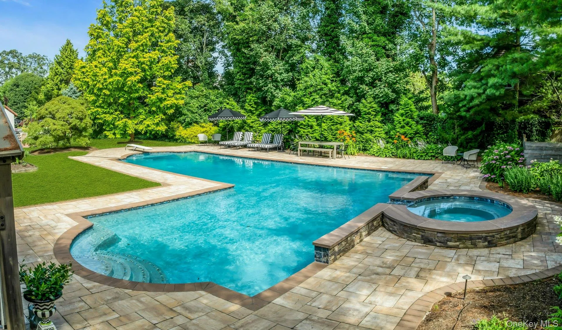 L-Shaped tiled gunite saltwater gas heated pool, with attached circular in-ground spa L-Shaped tiled gunite saltwater gas heated pool, with attached circular in-ground spa