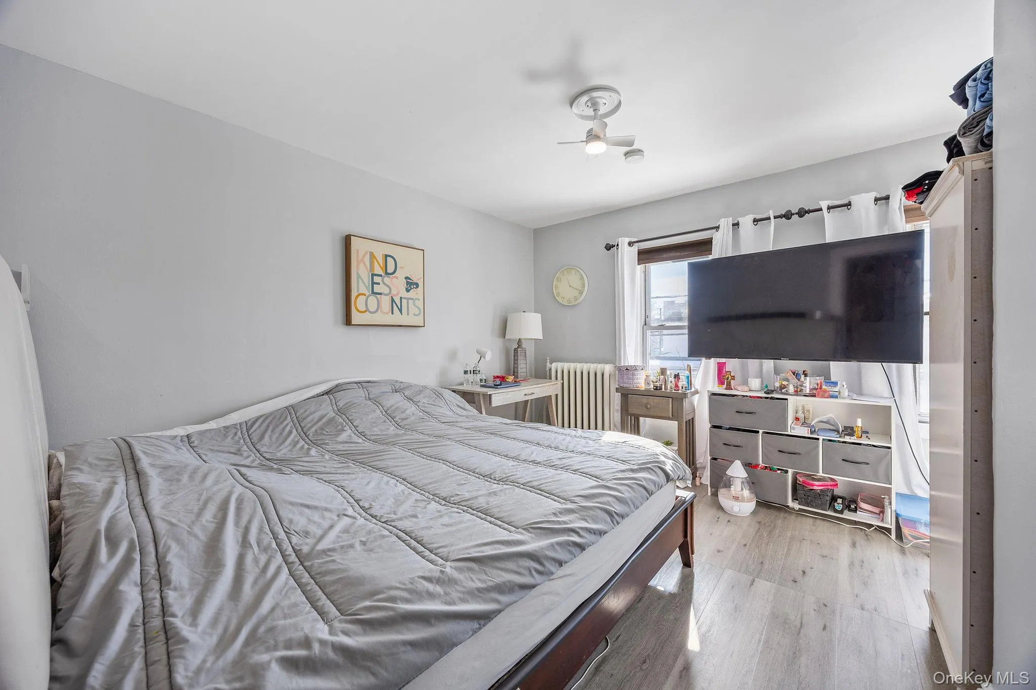Bedroom featuring light wood-style flooring and radiator heating unit Bedroom featuring light wood-style flooring and radiator heating unit