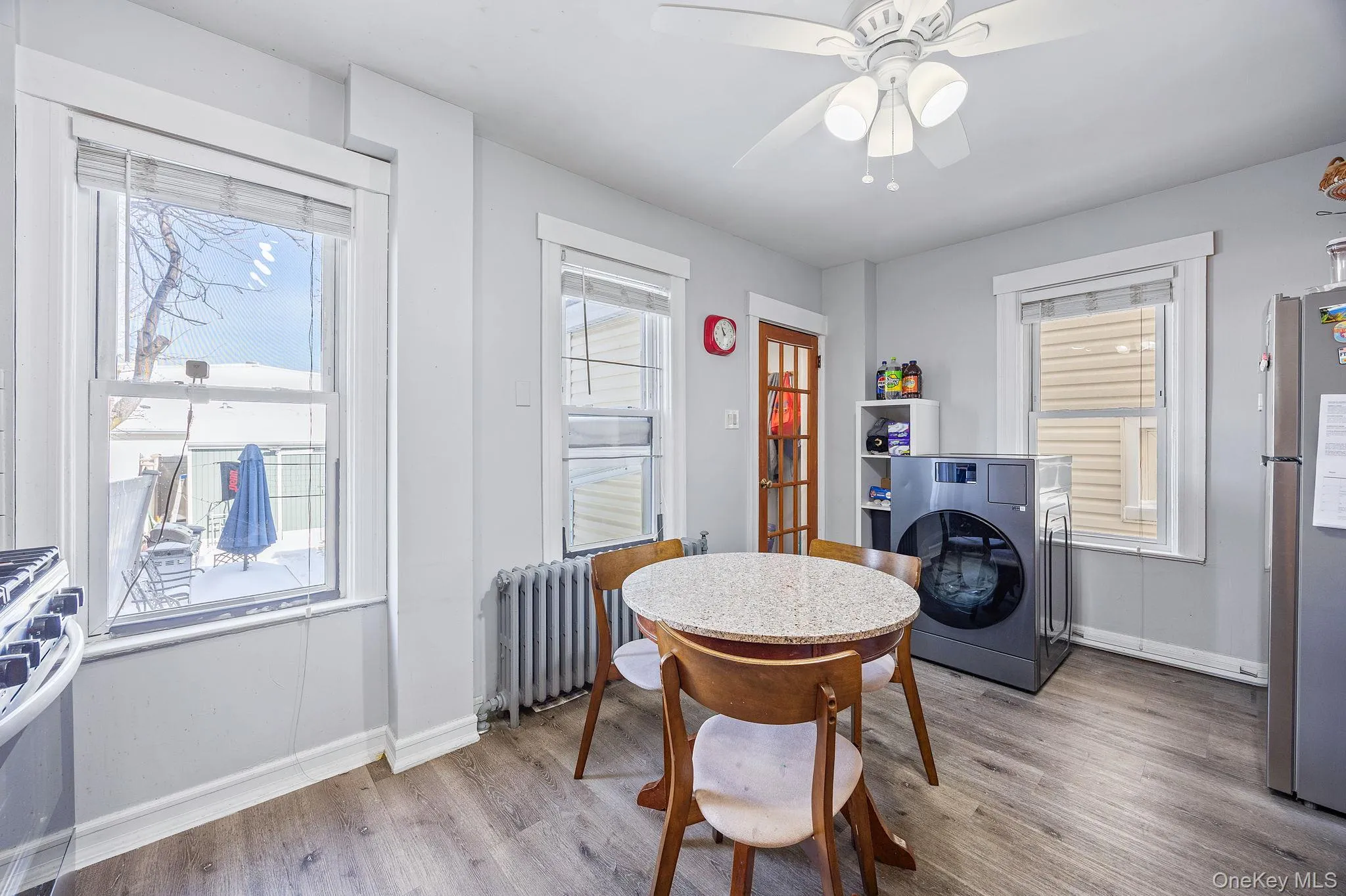 Dining area featuring washer / dryer, wood finished floors, ceiling fan, and radiator heating unit Dining area featuring washer / dryer, wood finished floors, ceiling fan, and radiator heating unit