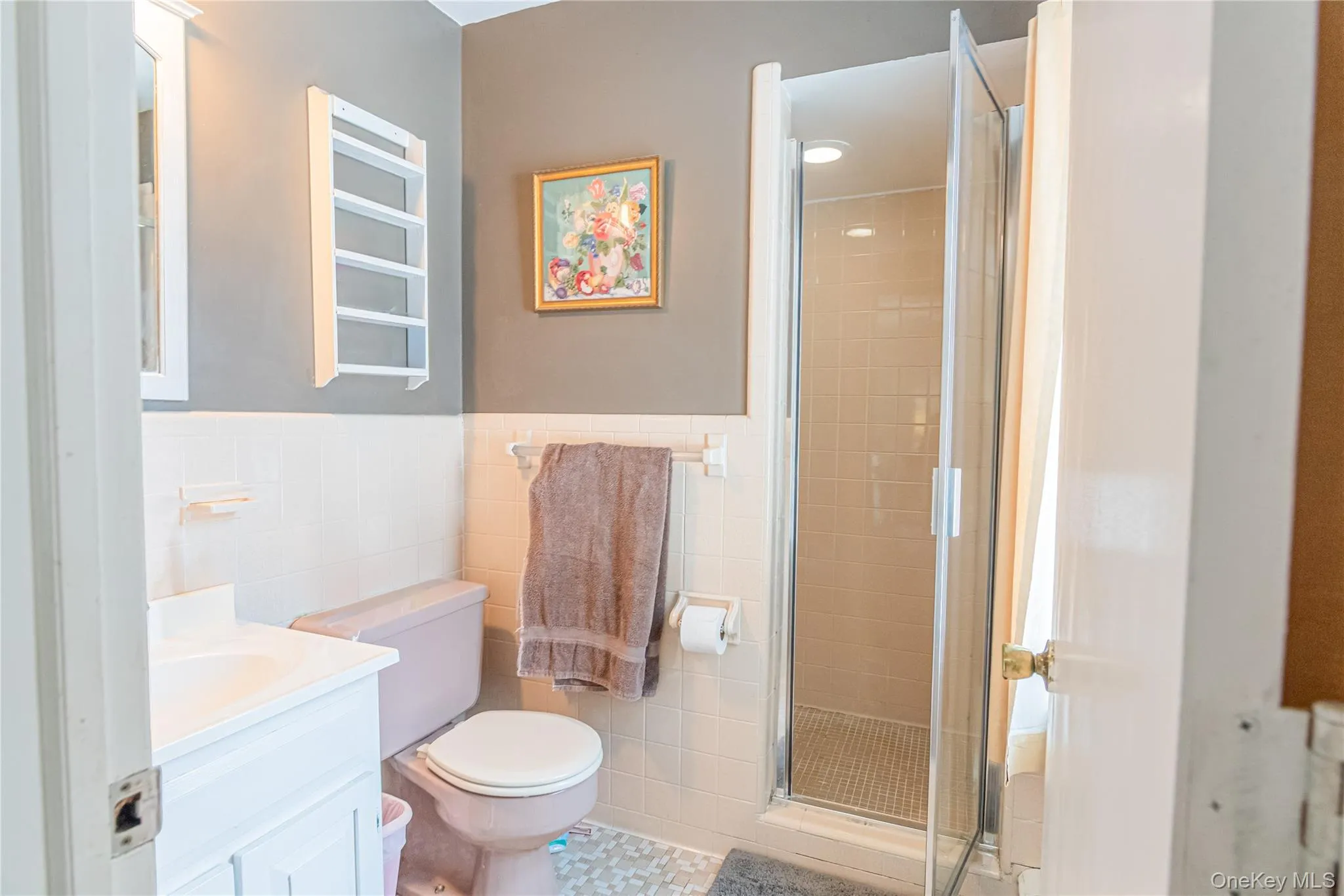 Full bathroom with a shower stall, vanity, tile walls, and wainscoting Full bathroom with a shower stall, vanity, tile walls, and wainscoting
