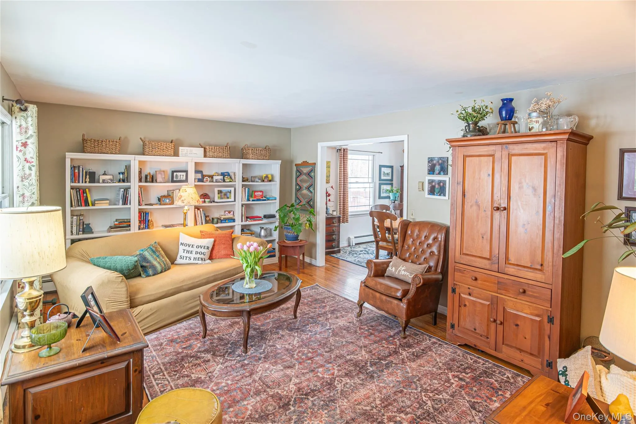 Living room featuring wood finished floors and baseboard heating Living room featuring wood finished floors and baseboard heating
