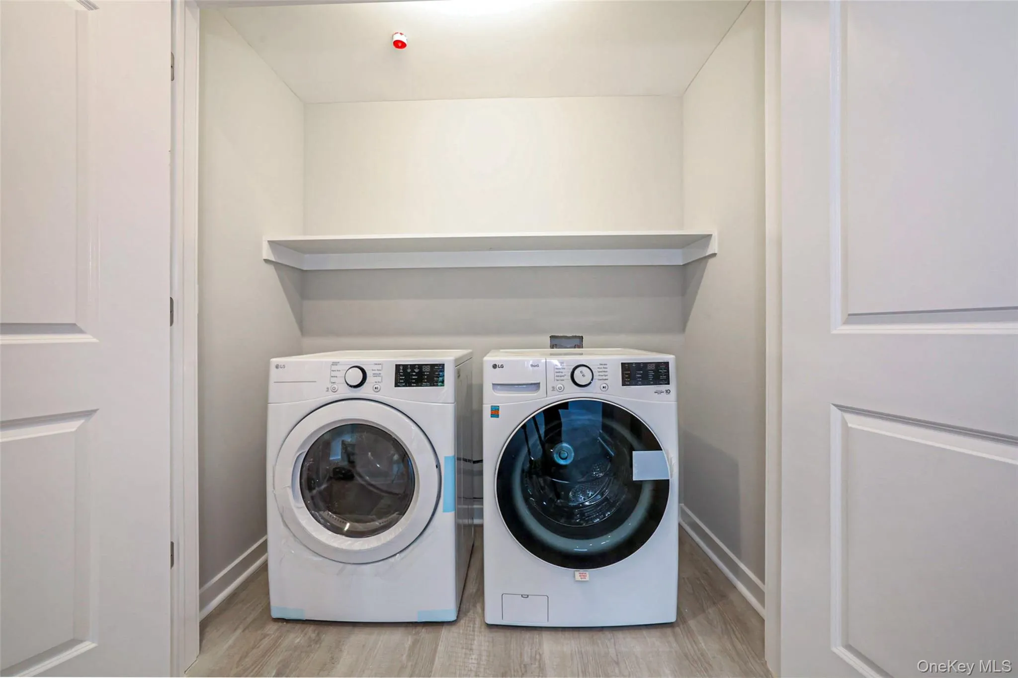 Laundry room with light wood finished floors and washing machine and dryer Laundry room with light wood finished floors and washing machine and dryer