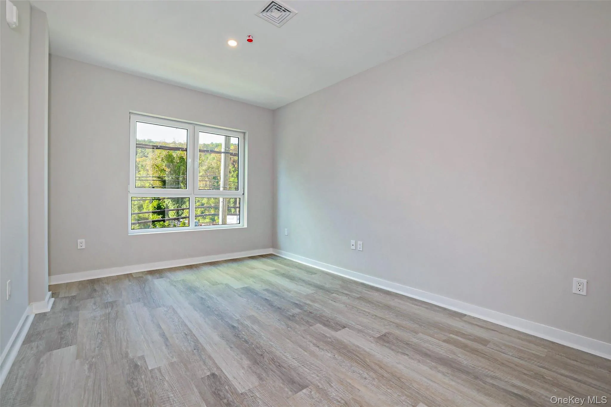 Unfurnished room with light wood finished floors and recessed lighting Unfurnished room with light wood finished floors and recessed lighting