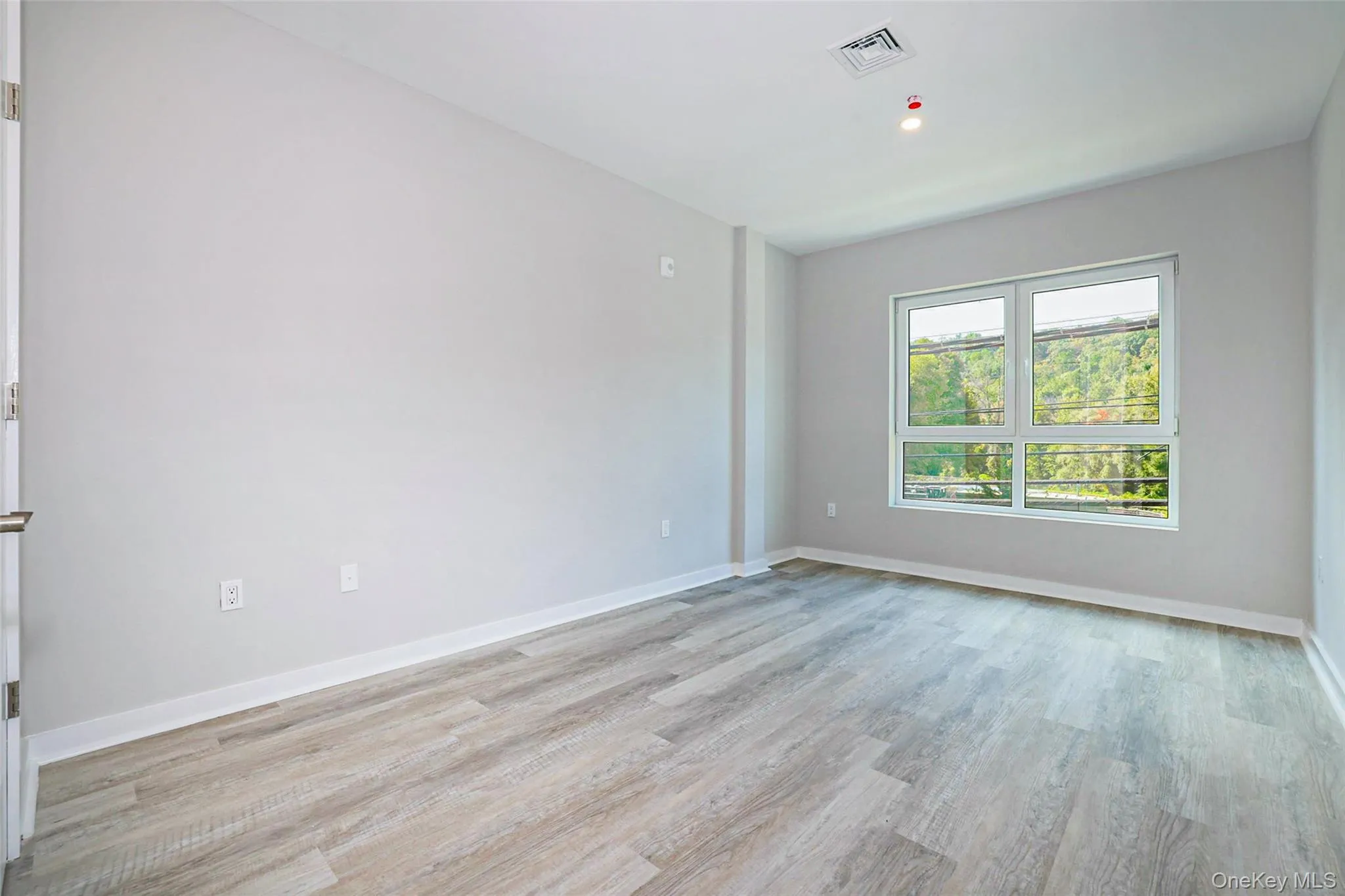 Empty room with baseboards and light wood-type flooring Empty room with baseboards and light wood-type flooring