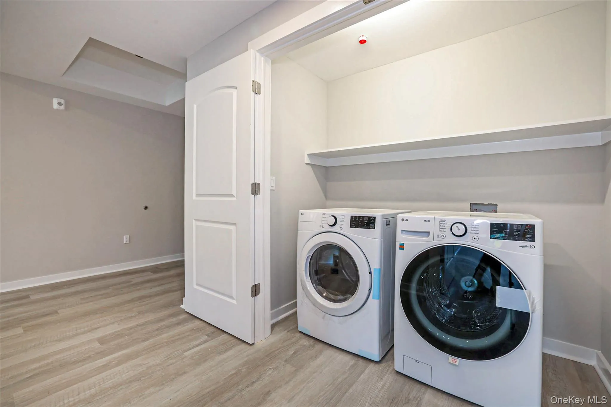 Washroom featuring light wood-type flooring and independent washer and dryer Washroom featuring light wood-type flooring and independent washer and dryer