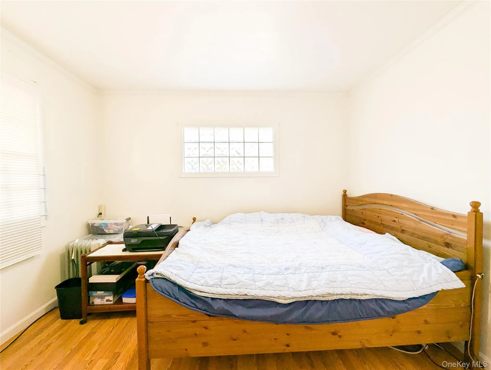 Bedroom featuring hardwood / wood-style flooring, crown molding, and radiator Bedroom featuring hardwood / wood-style flooring, crown molding, and radiator