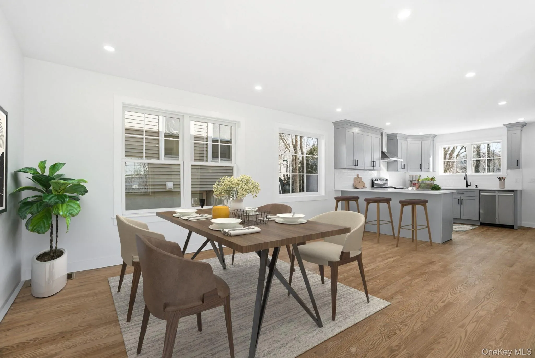 The kitchen showcases an island with stools for casual breakfast seating and a dining area, virtually staged to highlight the space. The kitchen showcases an island with stools for casual breakfast seating and a dining area, virtually staged to highlight the space.