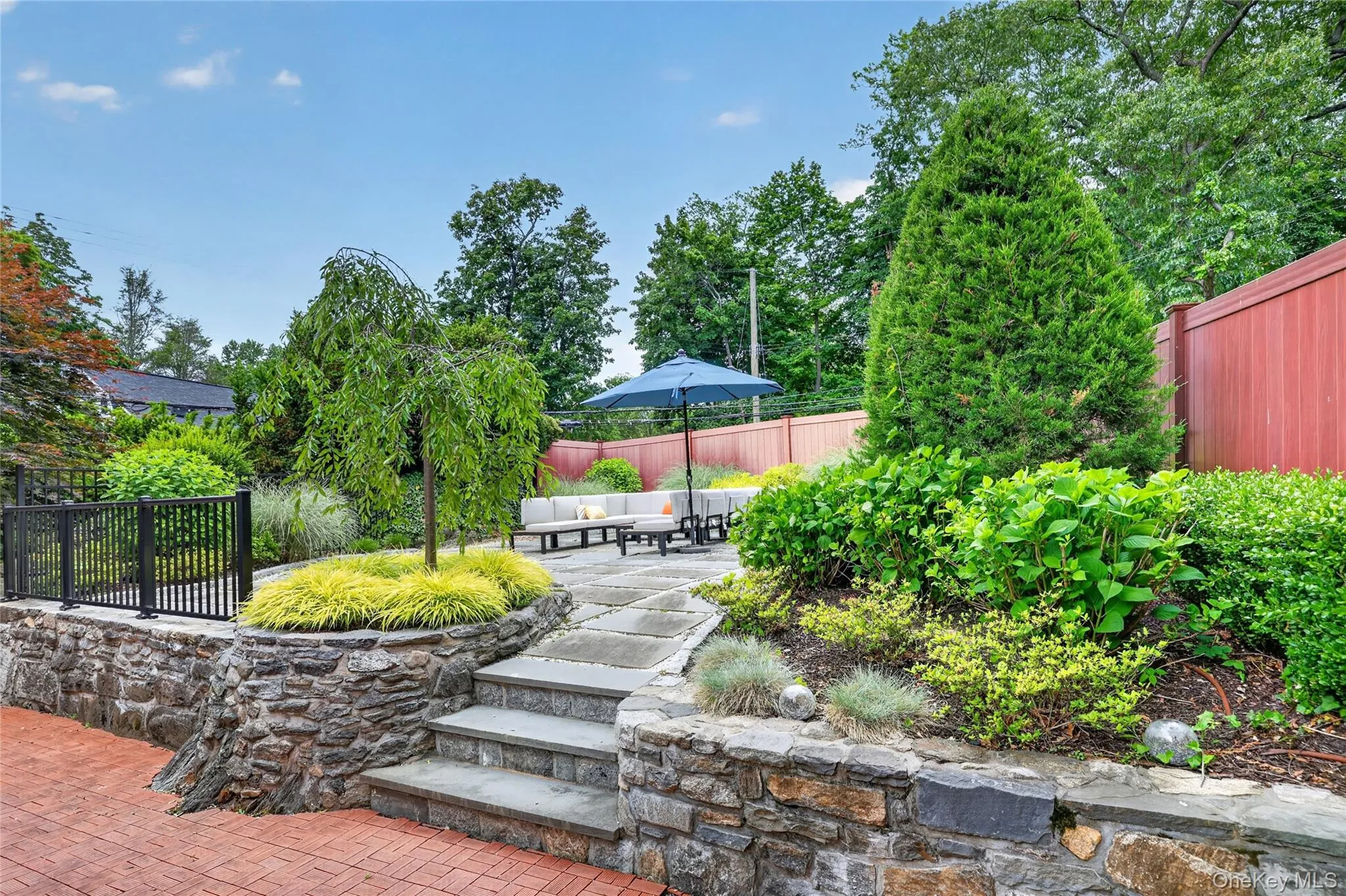Landscaped side yard with steps leading to raised stone patio Landscaped side yard with steps leading to raised stone patio