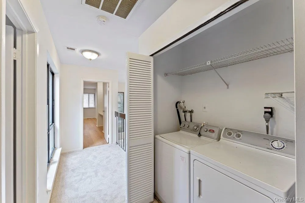 Laundry area featuring independent washer and dryer and light colored carpet Laundry area featuring independent washer and dryer and light colored carpet