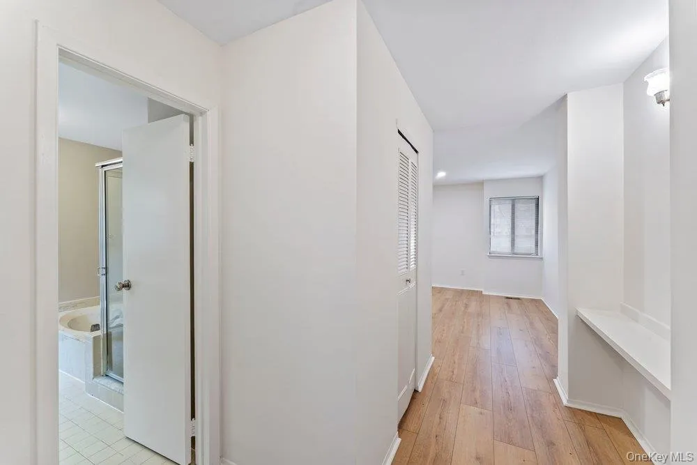 Corridor featuring light wood finished floors and baseboards Corridor featuring light wood finished floors and baseboards