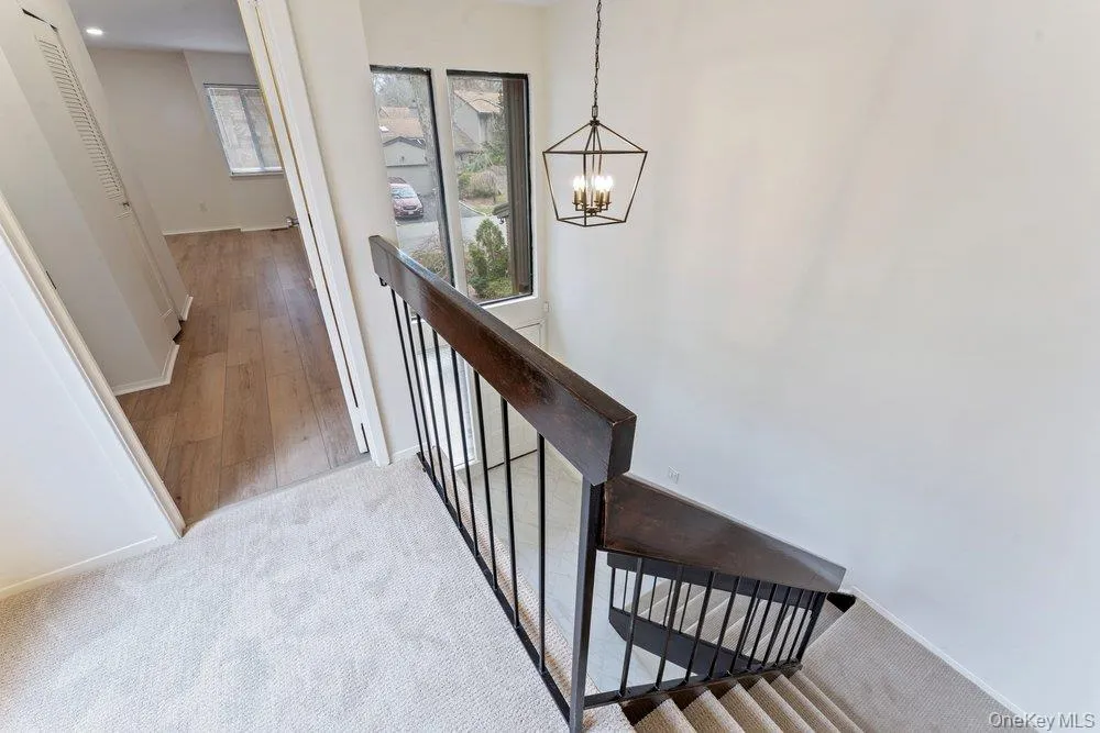 Staircase with carpet floors and a chandelier Staircase with carpet floors and a chandelier