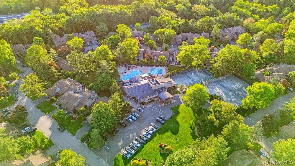 Aerial view of property and surrounding area with a pool area and nearby suburban area Aerial view of property and surrounding area with a pool area and nearby suburban area