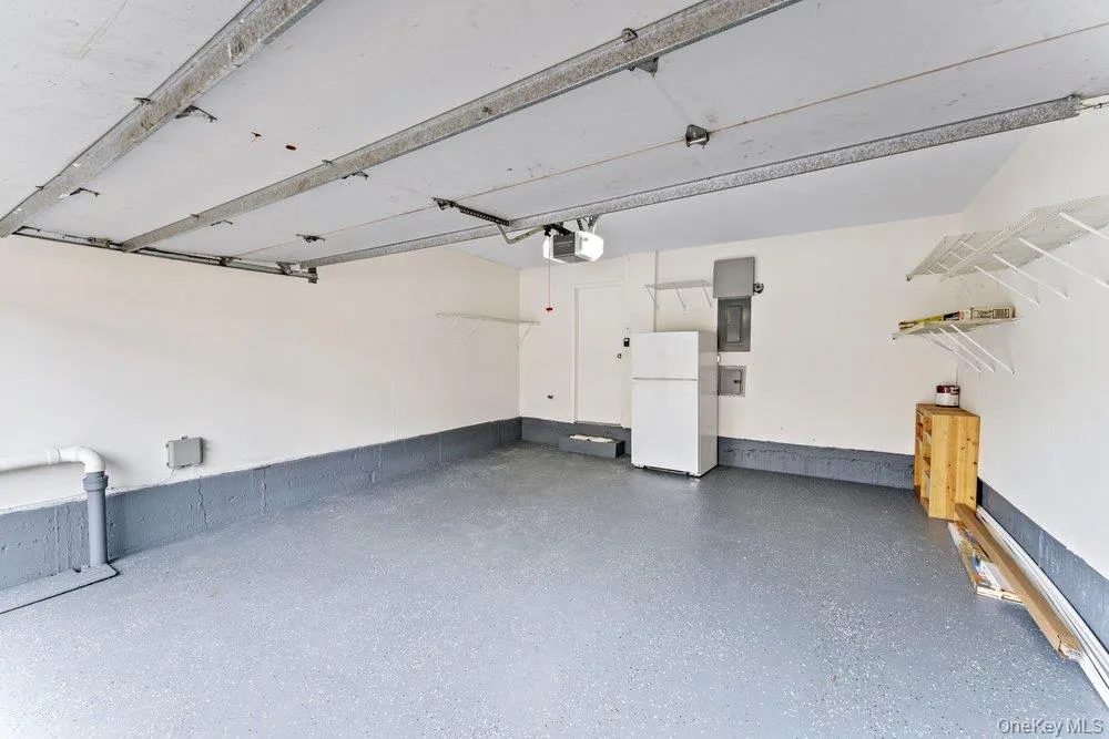 Garage with freestanding refrigerator and electric panel Garage with freestanding refrigerator and electric panel