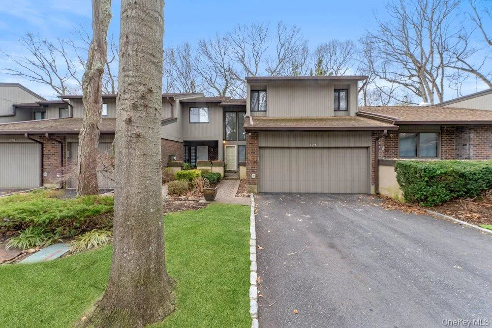 View of front facade featuring brick siding, driveway, and an attached garage View of front facade featuring brick siding, driveway, and an attached garage