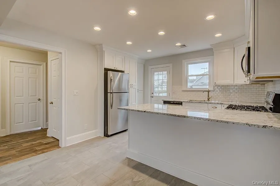 Open kitchen area. Back door to backyard and parking Open kitchen area. Back door to backyard and parking