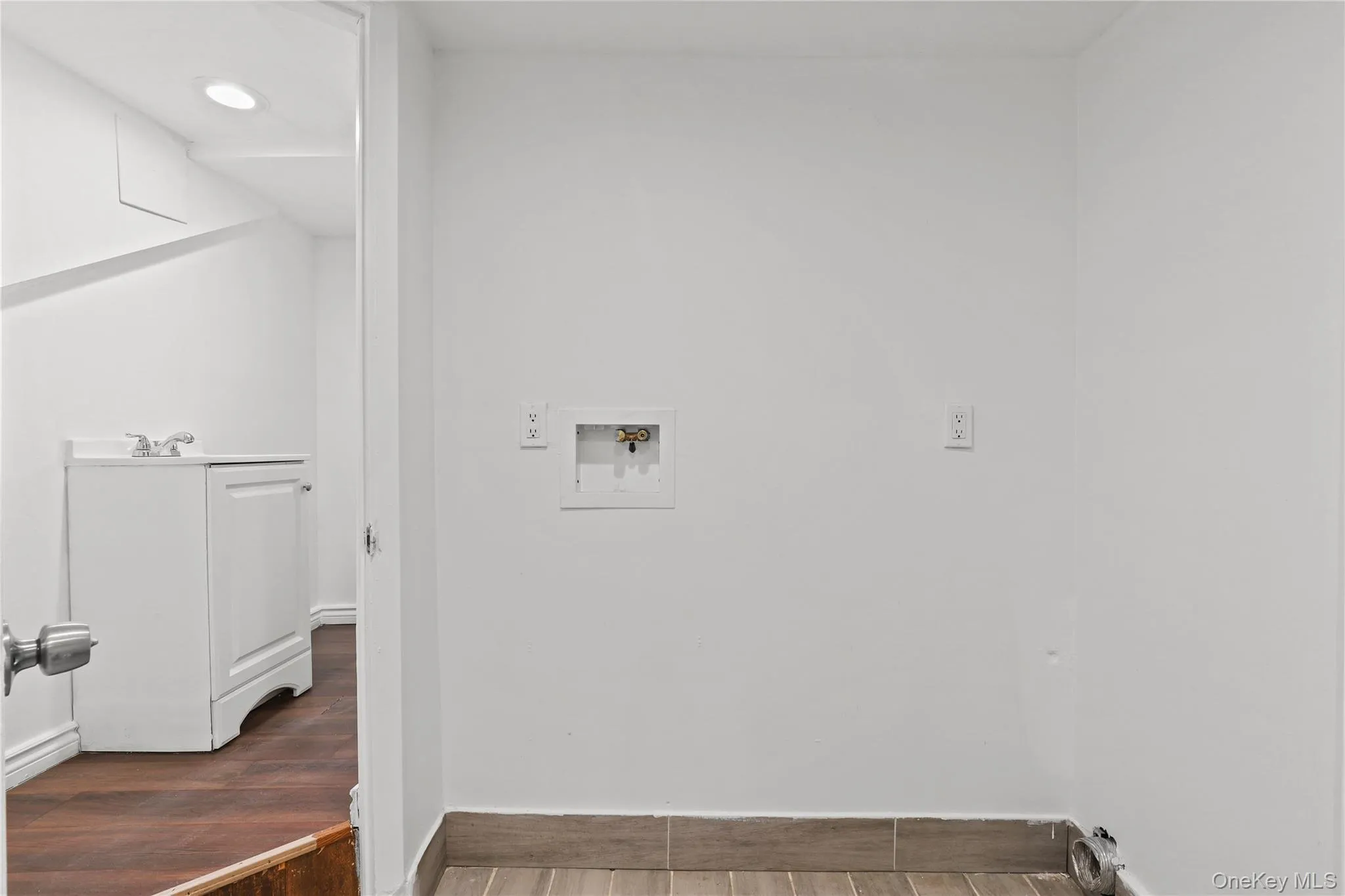 Laundry area featuring hookup for a washing machine, wood finished floors, and recessed lighting Laundry area featuring hookup for a washing machine, wood finished floors, and recessed lighting