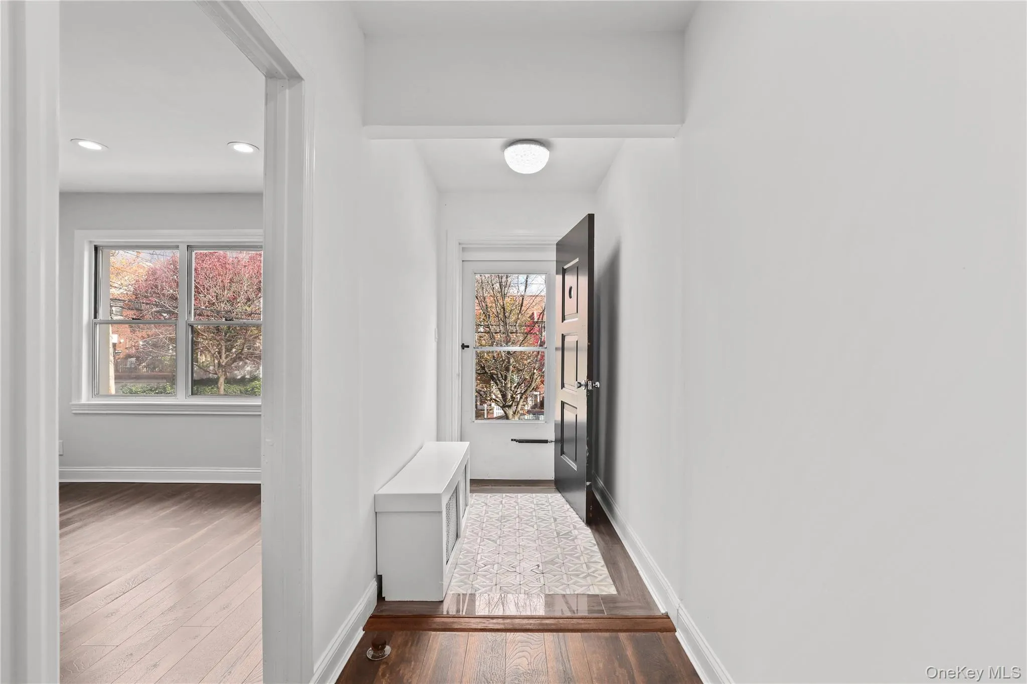 Hall with dark wood-style floors, plenty of natural light, and recessed lighting Hall with dark wood-style floors, plenty of natural light, and recessed lighting
