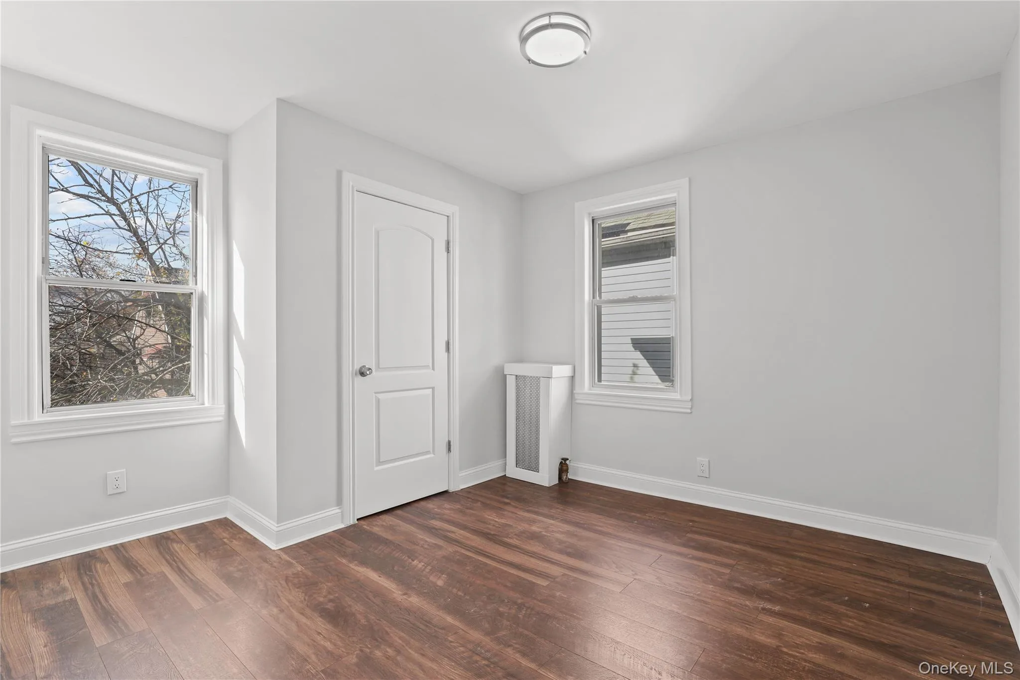 Unfurnished bedroom featuring baseboards and dark wood-style flooring Unfurnished bedroom featuring baseboards and dark wood-style flooring
