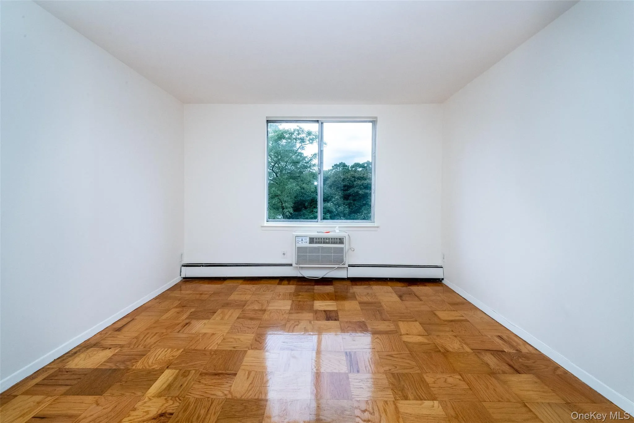 Unfurnished room featuring baseboards and a baseboard radiator Unfurnished room featuring baseboards and a baseboard radiator