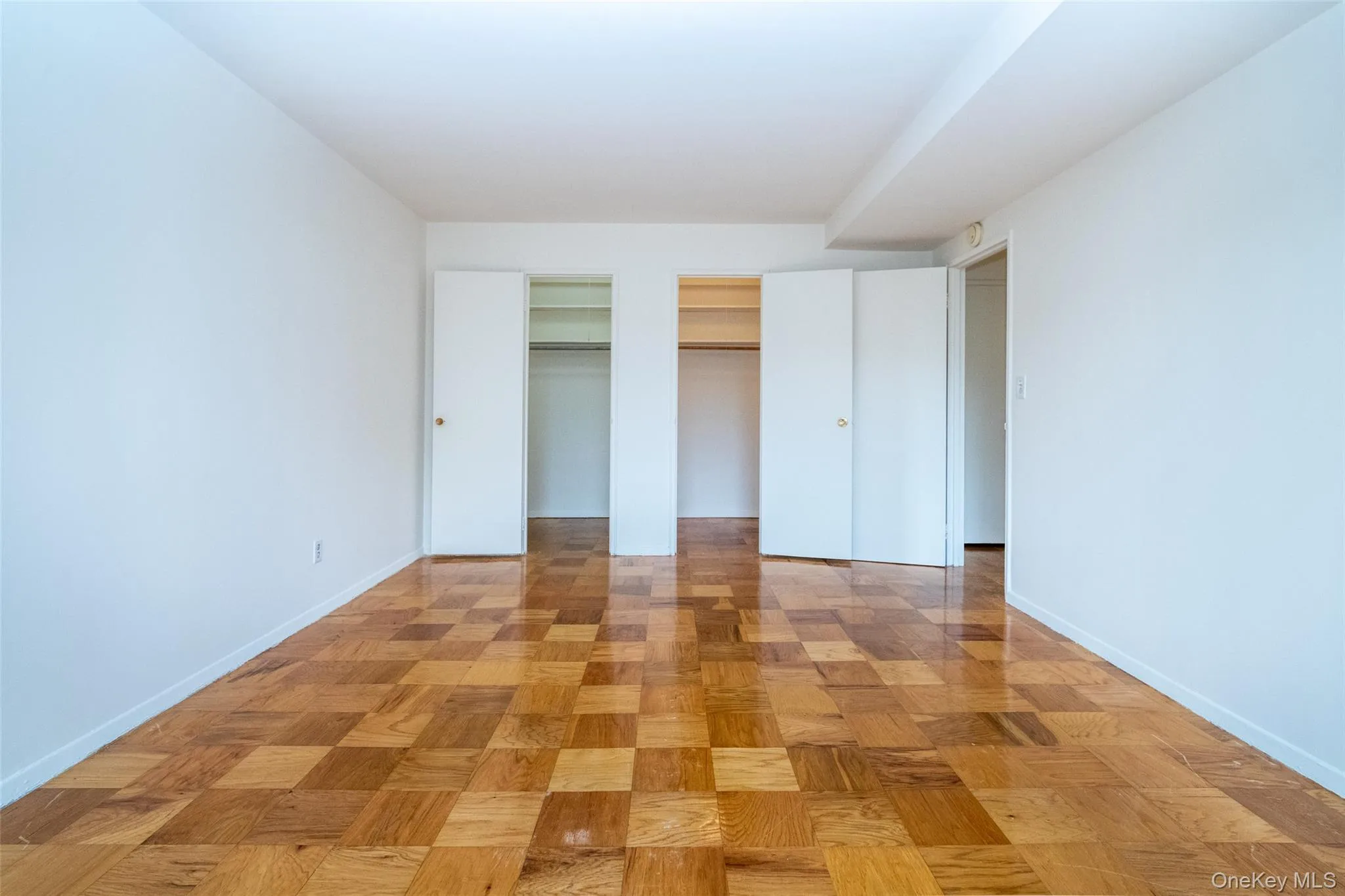 Unfurnished bedroom featuring two closets and baseboards Unfurnished bedroom featuring two closets and baseboards