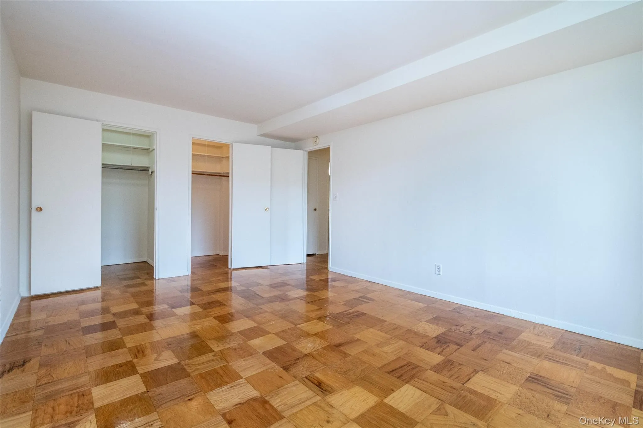 Unfurnished bedroom featuring multiple closets and baseboards Unfurnished bedroom featuring multiple closets and baseboards