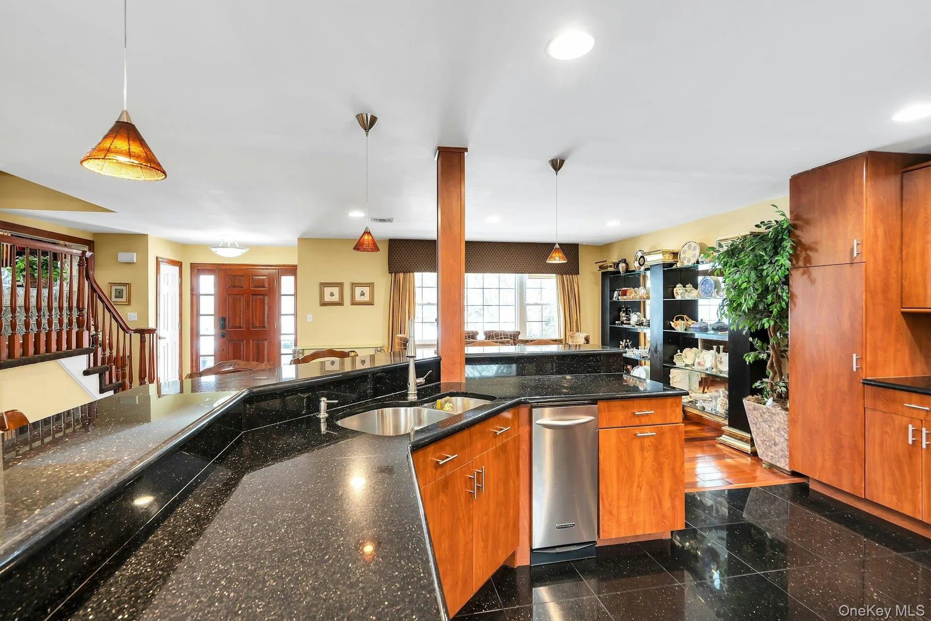 Kitchen featuring wood finish cabinetry, hanging light fixtures, and dark stone countertops Kitchen featuring wood finish cabinetry, hanging light fixtures, and dark stone countertops