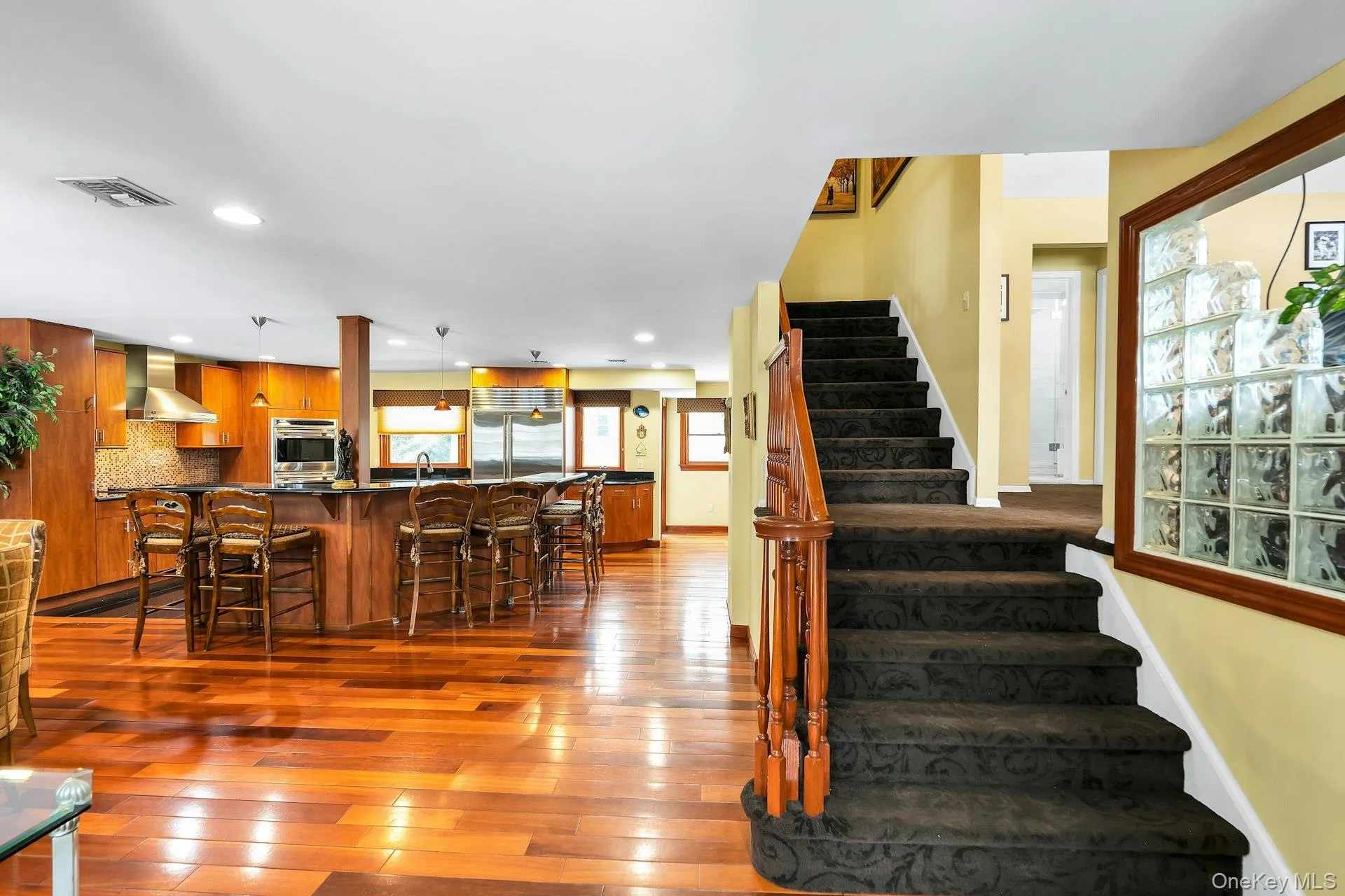 Staircase with hardwood / wood-style flooring and recessed lighting Staircase with hardwood / wood-style flooring and recessed lighting