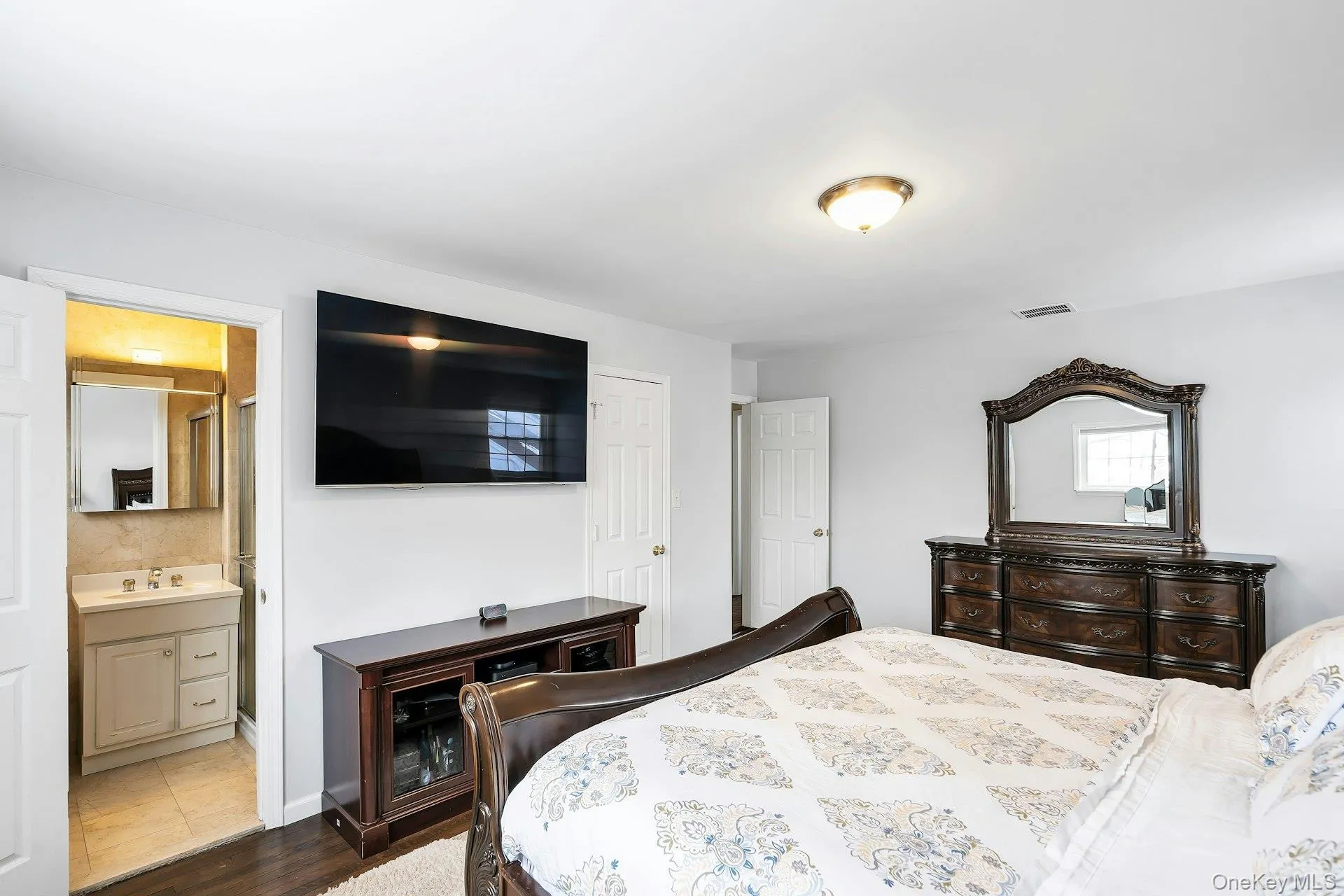Master Bedroom with dark wood-style flooring and connected bathroom Master Bedroom with dark wood-style flooring and connected bathroom