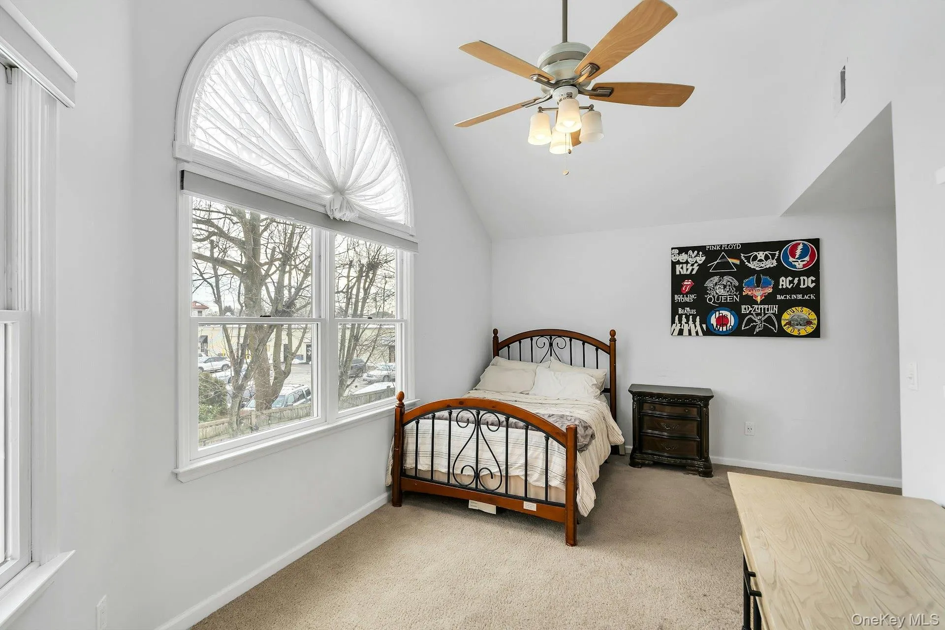Bedroom featuring light colored carpet, multiple windows, lofted ceiling, and ceiling fan Bedroom featuring light colored carpet, multiple windows, lofted ceiling, and ceiling fan