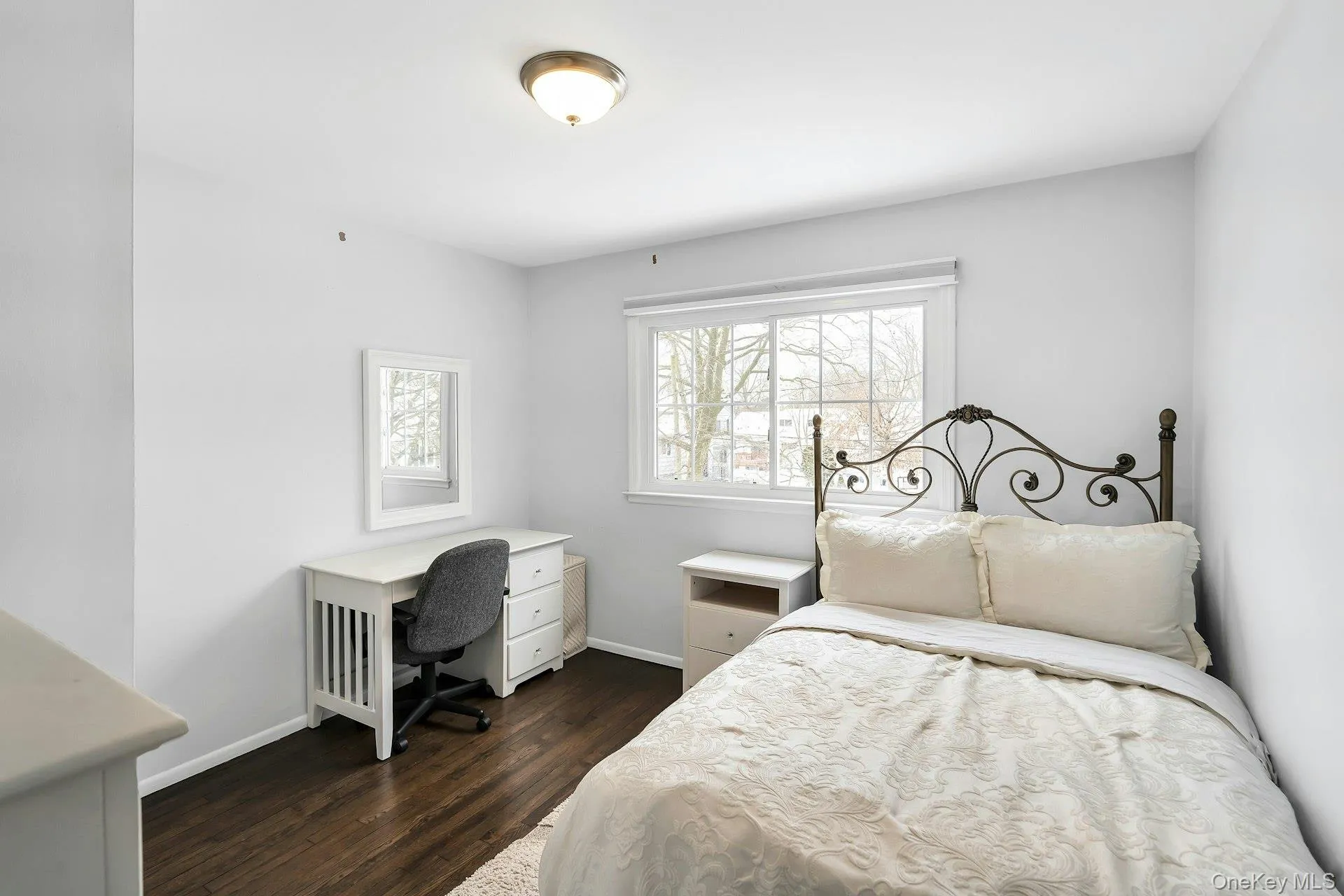 Bedroom with dark wood finished floors and a desk Bedroom with dark wood finished floors and a desk